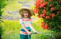 Cute child in straw hat is laughing with water spraying hose. Royalty Free Stock Photo