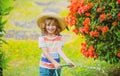 Cute child in straw hat is laughing with water spraying hose. Royalty Free Stock Photo