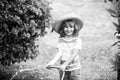 Cute child in straw hat is laughing with water spraying hose. Royalty Free Stock Photo