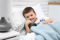 Cute child with stuffed bunny resting in bed