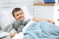 Cute child with stuffed bunny resting in bed