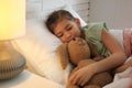 Cute child with stuffed bunny resting in bed