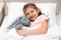 Cute child with stuffed rabbit resting in bed