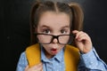 Cute child wearing glasses near chalkboard. First time at school Royalty Free Stock Photo