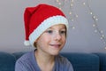 A cute child wearing a knitted Santa hat. Xmas design. Enchantment, surprise, astonishment, wonder expression Royalty Free Stock Photo