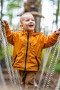 Cute Child Wearing Orange Raincoat Playing on Playground