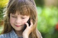 Cute child young girl talking on cellphone outdoors. Children and modern technology, communication concept Royalty Free Stock Photo