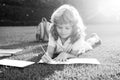 Cute childr boy with books with pencil writing on notebook outdoors. Summer camp. Kids learning and education concept Royalty Free Stock Photo