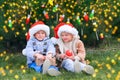 Cute children decorate Christmas trees in garland and balls decorated backyard