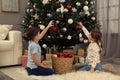 Cute little children decorating Christmas tree at home Royalty Free Stock Photo