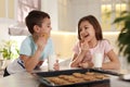 Cute children eating cookies with milk in kitchen. Cooking pastry