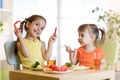 Cute children girls eating healthy food. Kids lunch at home or kindergarten. Royalty Free Stock Photo