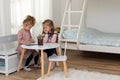 Cute children girls are reading a book in room at home. Two sister girls reading a book and having fun Royalty Free Stock Photo