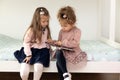 Cute children girls reading a book in room at home. Two sister girls reading a book and having fun Royalty Free Stock Photo