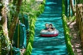 Cute children, going down on a big slide in a circle summer sled