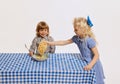 Cute children, kids playing, having fun, tasting corn flakes together isolated over white background. Concept of