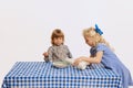 Cute children, kids playing, having fun, tasting corn flakes together over white background. Concept of