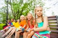 Cute children with notebooks sit on bench