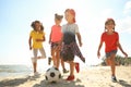 Cute children playing soccer at beach on sunny day. Summer camp Royalty Free Stock Photo