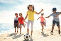 Cute children playing soccer at beach on sunny day. Summer camp Royalty Free Stock Photo