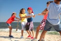 Cute children pulling rope during tug of war game on beach. Summer camp Royalty Free Stock Photo