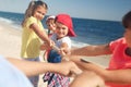 Cute children pulling rope during tug of war game on beach. Summer camp Royalty Free Stock Photo