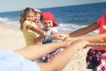 Cute children pulling rope during tug of war game on beach. Summer camp Royalty Free Stock Photo