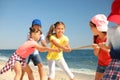 Cute children pulling rope during tug of war game on beach. Summer camp Royalty Free Stock Photo