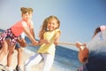 Cute children pulling rope during tug of war game on beach. Summer camp Royalty Free Stock Photo