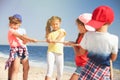 Cute children pulling rope during tug of war game on beach. Summer camp Royalty Free Stock Photo