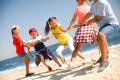 Cute children pulling rope during tug of war game on beach. Summer camp Royalty Free Stock Photo