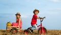 Cute children riding on tricycle on farm. Children farmer concept. Children enjoy in farm. Little farmer in village