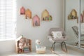 Cute children`s room with house shaped shelves and rocking chair. Interior