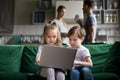 Cute children sister and brother holding laptop watching online