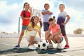 Cute children with soccer ball at sports court on sunny day. Summer camp