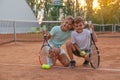 Cute children with tennis rackets and balls on court outdoors Royalty Free Stock Photo