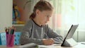 Cute children use laptop for education, online study, home studying. Girl has homework at distance learning. Concept for Royalty Free Stock Photo