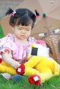 Cute Chinese baby girl play plush toy on the lawn Royalty Free Stock Photo