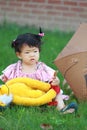Cute Chinese baby girl play plush toy on the lawn Royalty Free Stock Photo