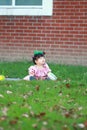 Cute Chinese baby girl wears glasses on the lawn Royalty Free Stock Photo