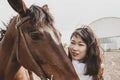 Cute chinese cowgirl while taking care of her horse Royalty Free Stock Photo