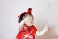 Cute Chinese little baby in red cheongsam play soap bubbles Royalty Free Stock Photo