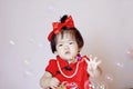 Cute Chinese little baby in red cheongsam play soap bubbles Royalty Free Stock Photo