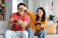 Cute chinese lovers having fun at home, playing video games Royalty Free Stock Photo