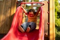 Cute Chinese Toddler Baby Girl Riding Slide At Park Outside Royalty Free Stock Photo