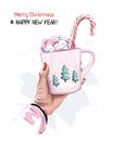 Cute christmas style cup with marshmallow and candy cane. Female hand holding cup. New Year style.