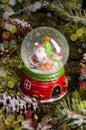 A cute Christmas toy, a snow globe with Santa Claus, a snowman and a Christmas tree inside. Christmas gift idea Royalty Free Stock Photo