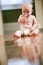 Cute chubby baby wearing diaper sitting on floor