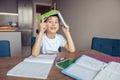 Cute clever Caucasian schoolboy holding book over head. Having idea. Know solution.