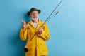 Cute clever lucky fishmen pointing up holding rod Royalty Free Stock Photo